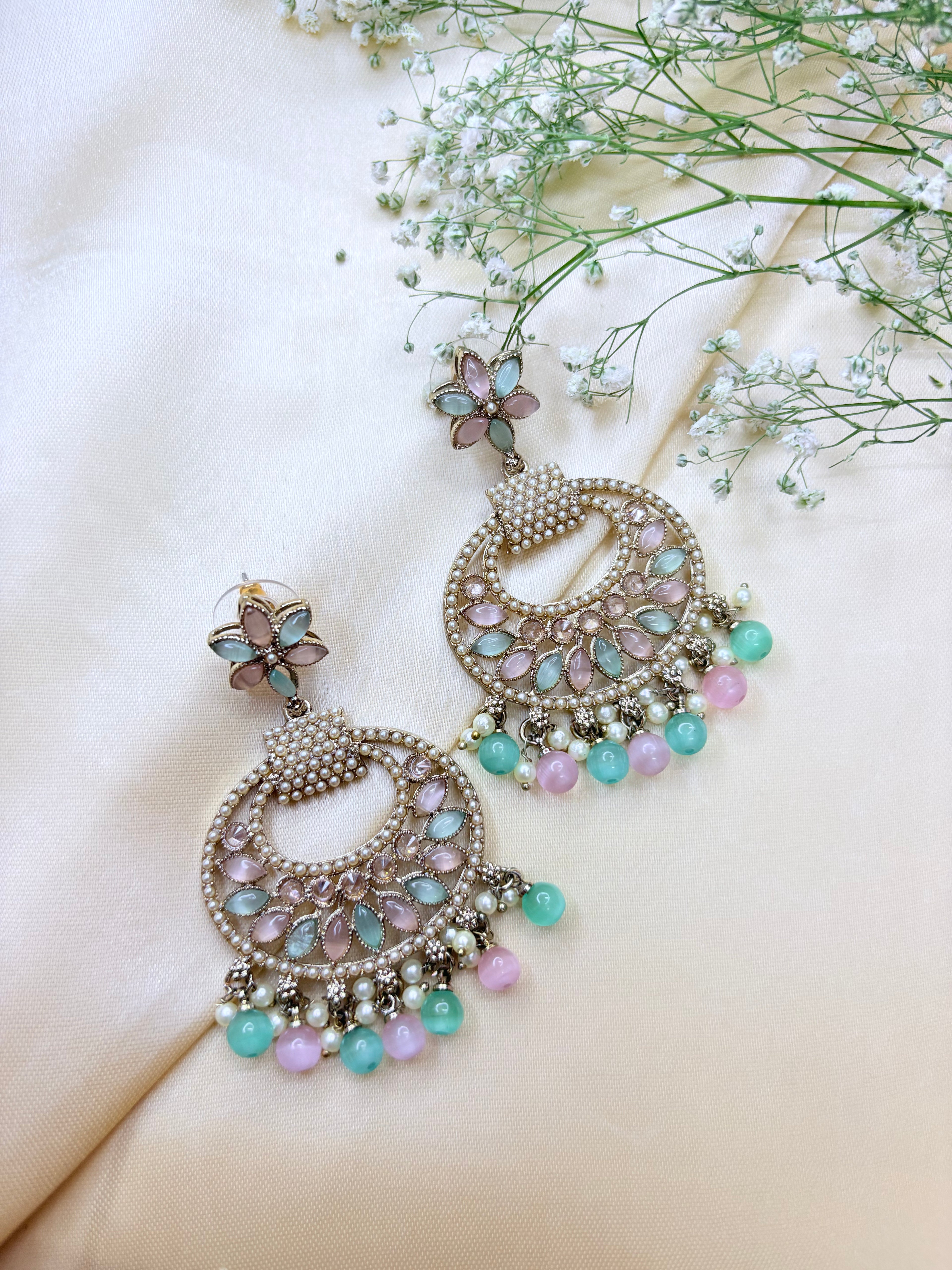 Decorative earrings with pastel beads on a soft background
